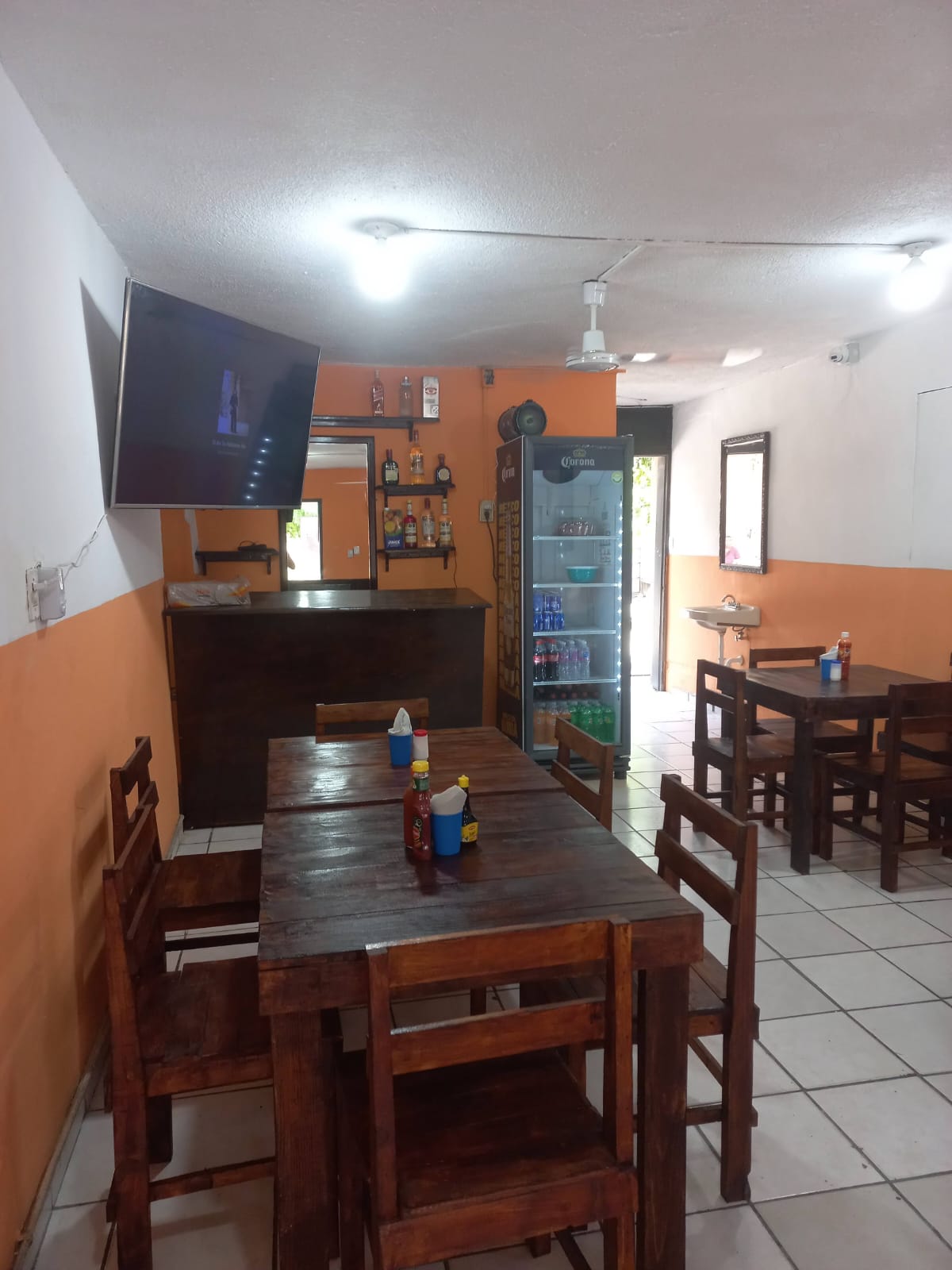 Interior del local con mesas de madera